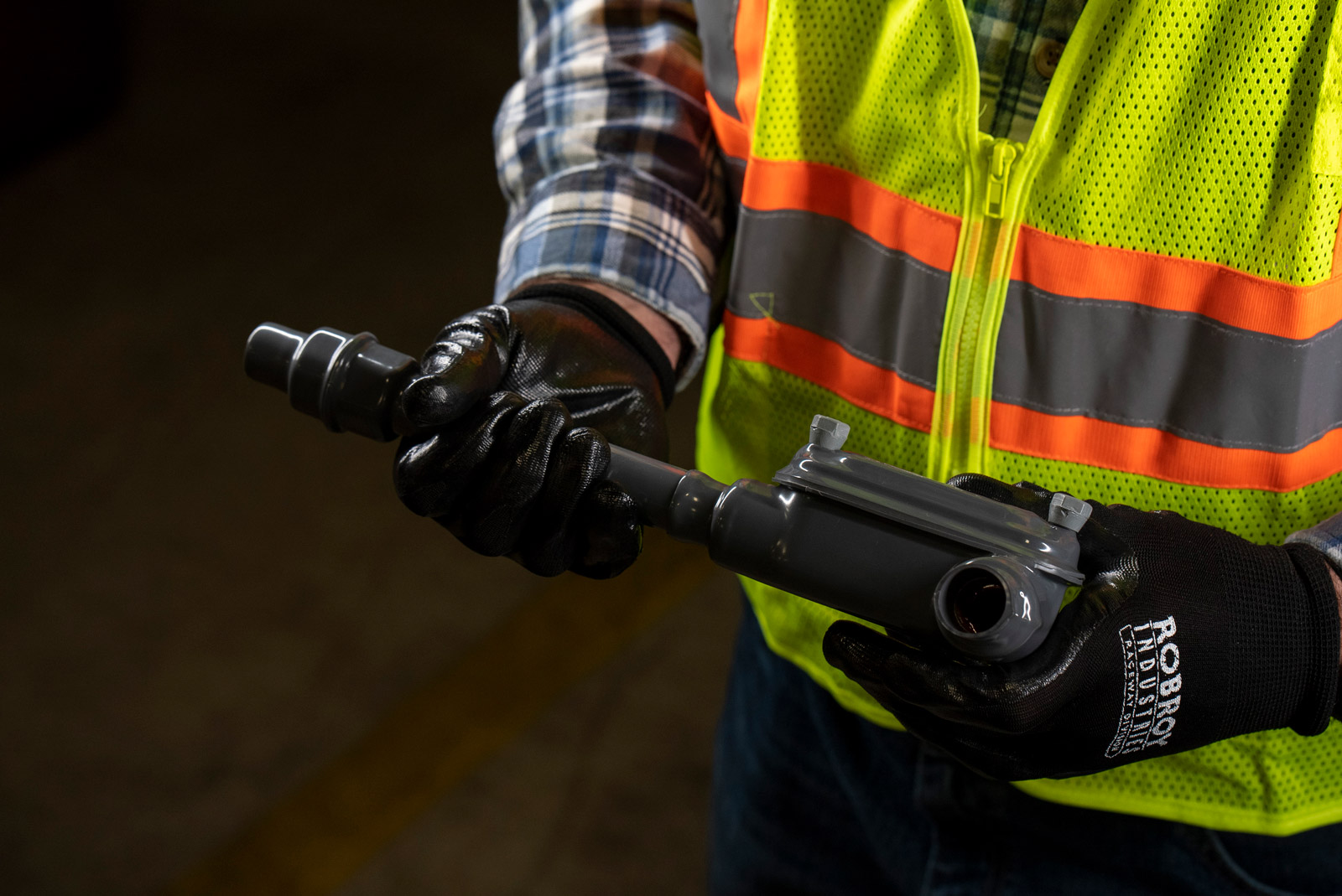 An electrical contractor grasping the rugged Perma-Cote PVC-coated fittings